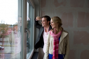 man en vrouw kijken uit een raam