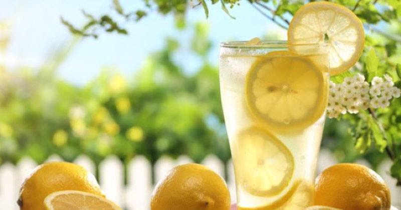 zomer in de tuin met een glas met water en citroenen