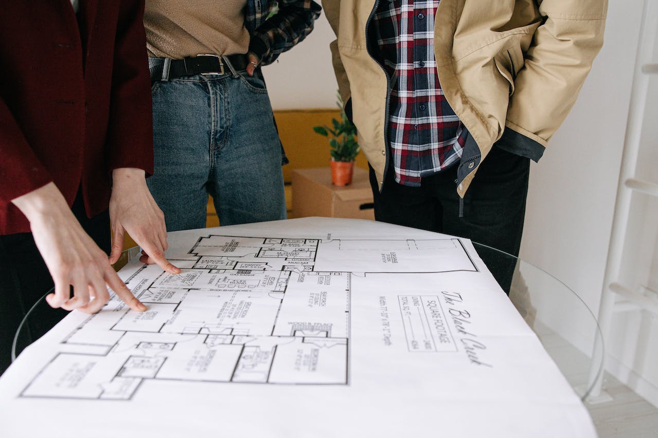Kopers bekijken plattegrond van een woning tijdens voorbereiding op aankoop