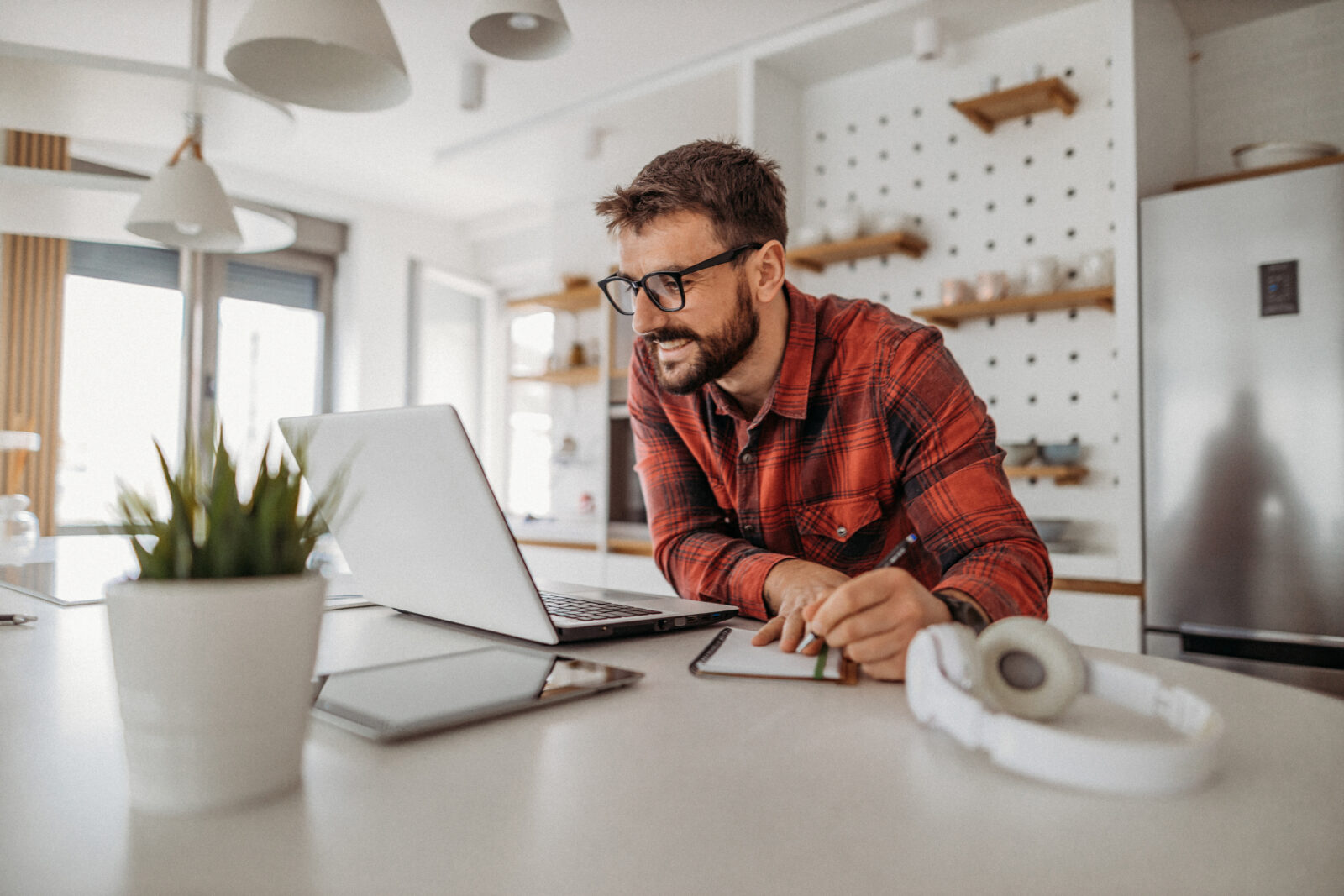 Man vergelijkt hypotheekinformatie op laptop aan keukentafel