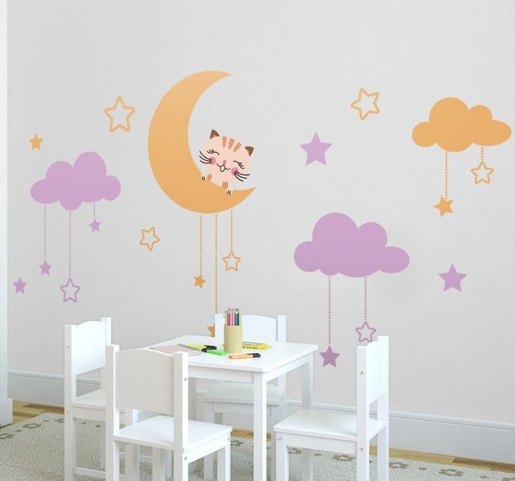 Babykamer met muurstickers van maan, sterren en wolken boven kindertafel