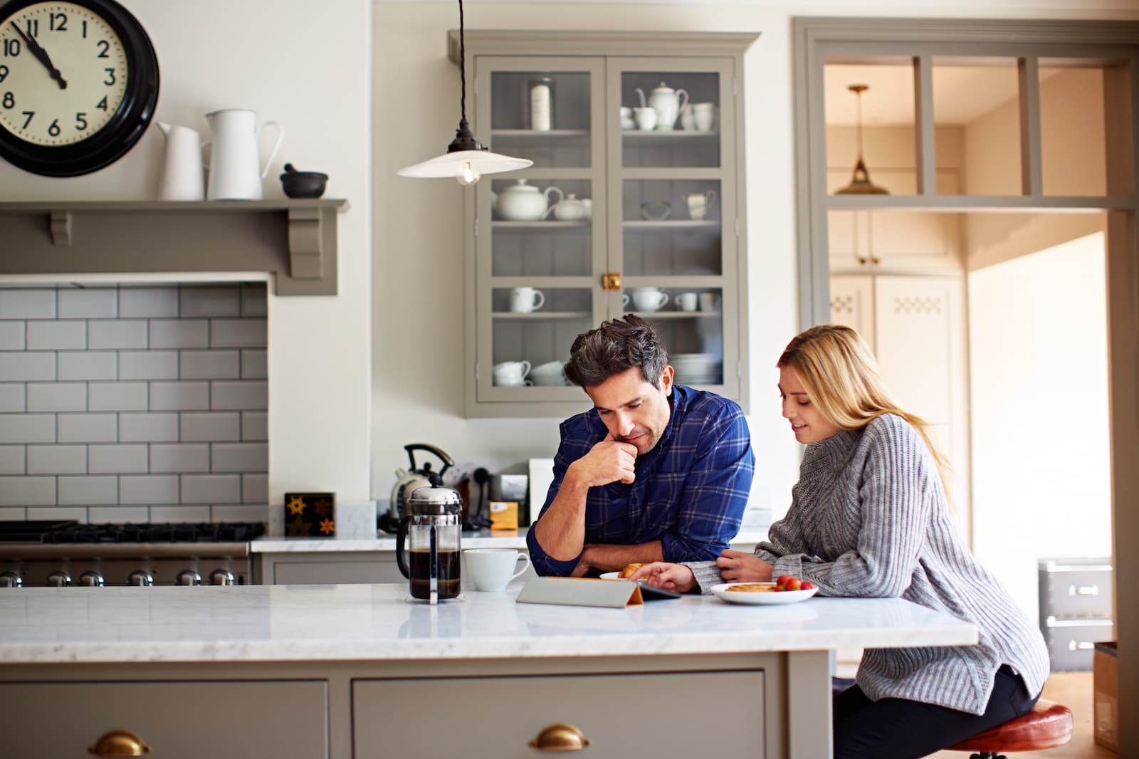 Stel bekijkt samen een energiecontract op een tablet in de keuken