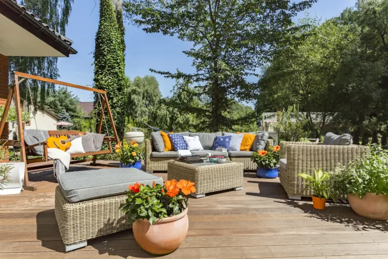 Verzorgde tuin met houten terras, loungeset en groene beplanting