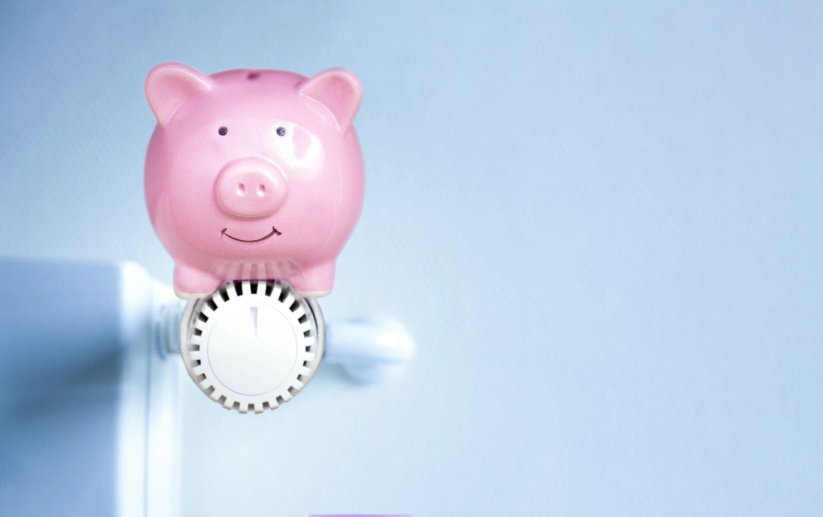 Spaarvarken op radiator als symbool voor energie besparen in huis