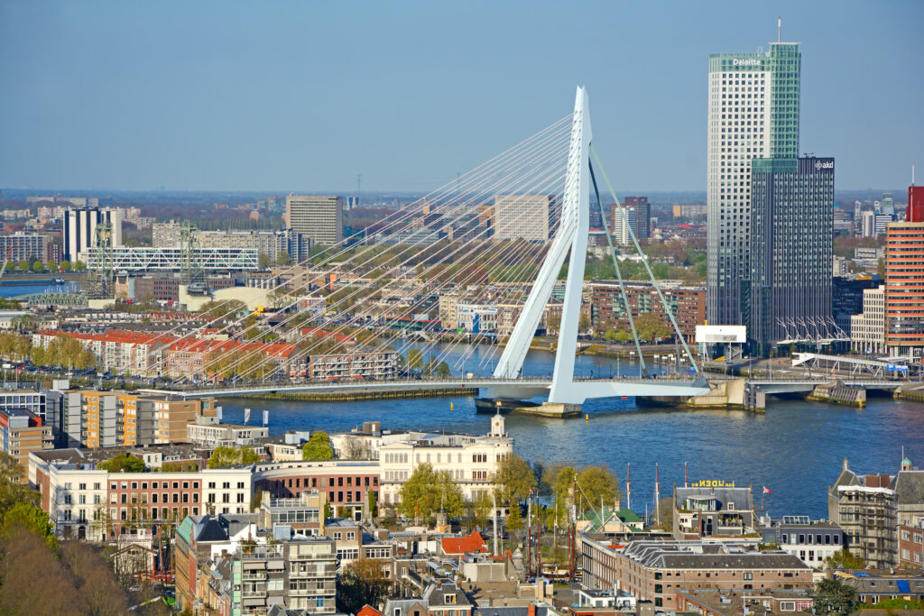 Skyline van Rotterdam met de Erasmusbrug en omliggende moderne gebouwen, een populaire stad voor ondernemers en bewoners vanwege de dynamische werkomgeving en goede voorzieningen.