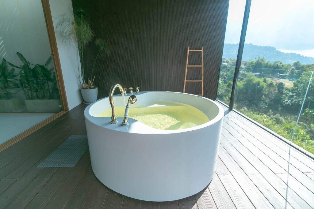 Moderne ronde jacuzzi op een houten terras met panoramisch uitzicht, ideaal voor ontspanning en wellness