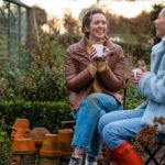 Vrouwen genieten van een kopje koffie in een tuin, waarbij ze ontspannen in de buitenlucht.