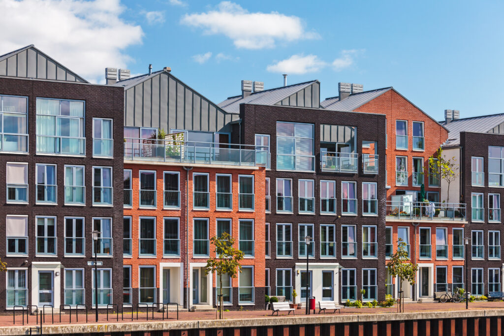 Moderne residentiële vastgoedgebouwen met grote ramen en balkons, gelegen langs het water.