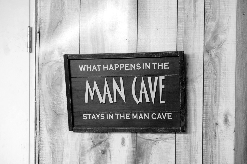 Mancave bord aan houten wand van tuinhuis dat is ingericht als persoonlijke ontspanningsruimte