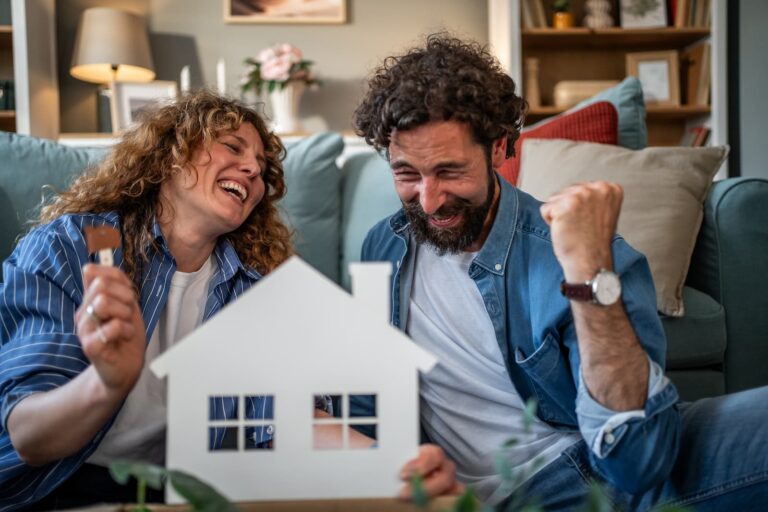 een stel is blij dat ze hun eerste huis hebben gekocht