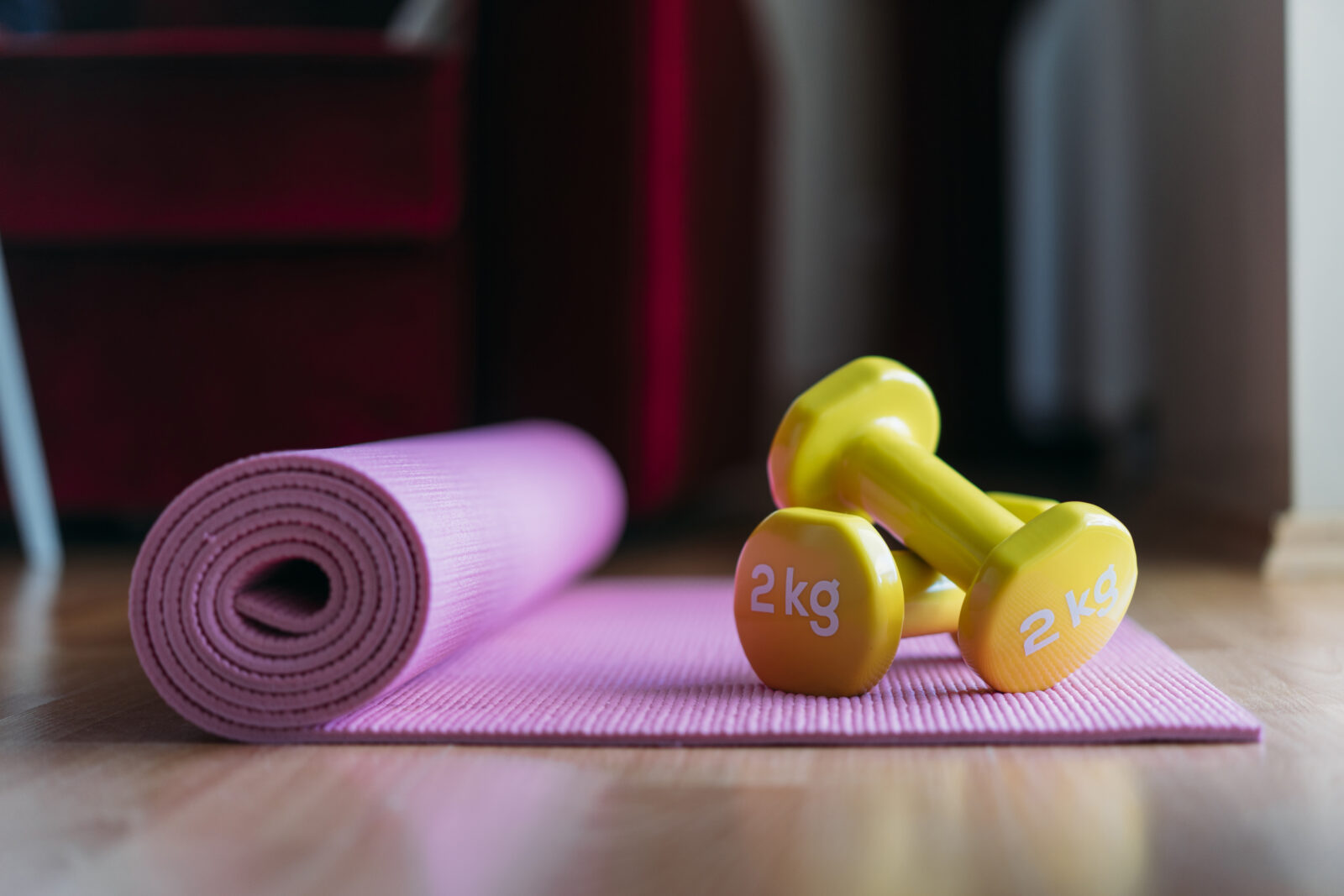Dumbbells en yogamat op de vloer voor thuis sporten en preventieve gezondheid