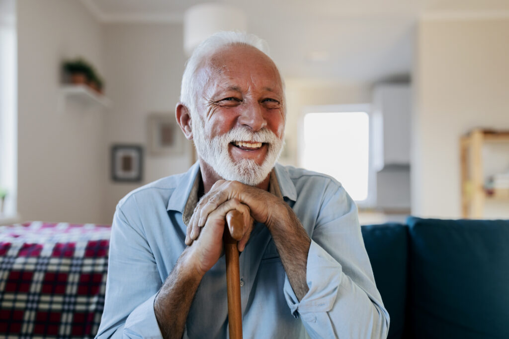 Blije oudere man in een comfortabele mantelzorgwoning met maatwerk voorzieningen.