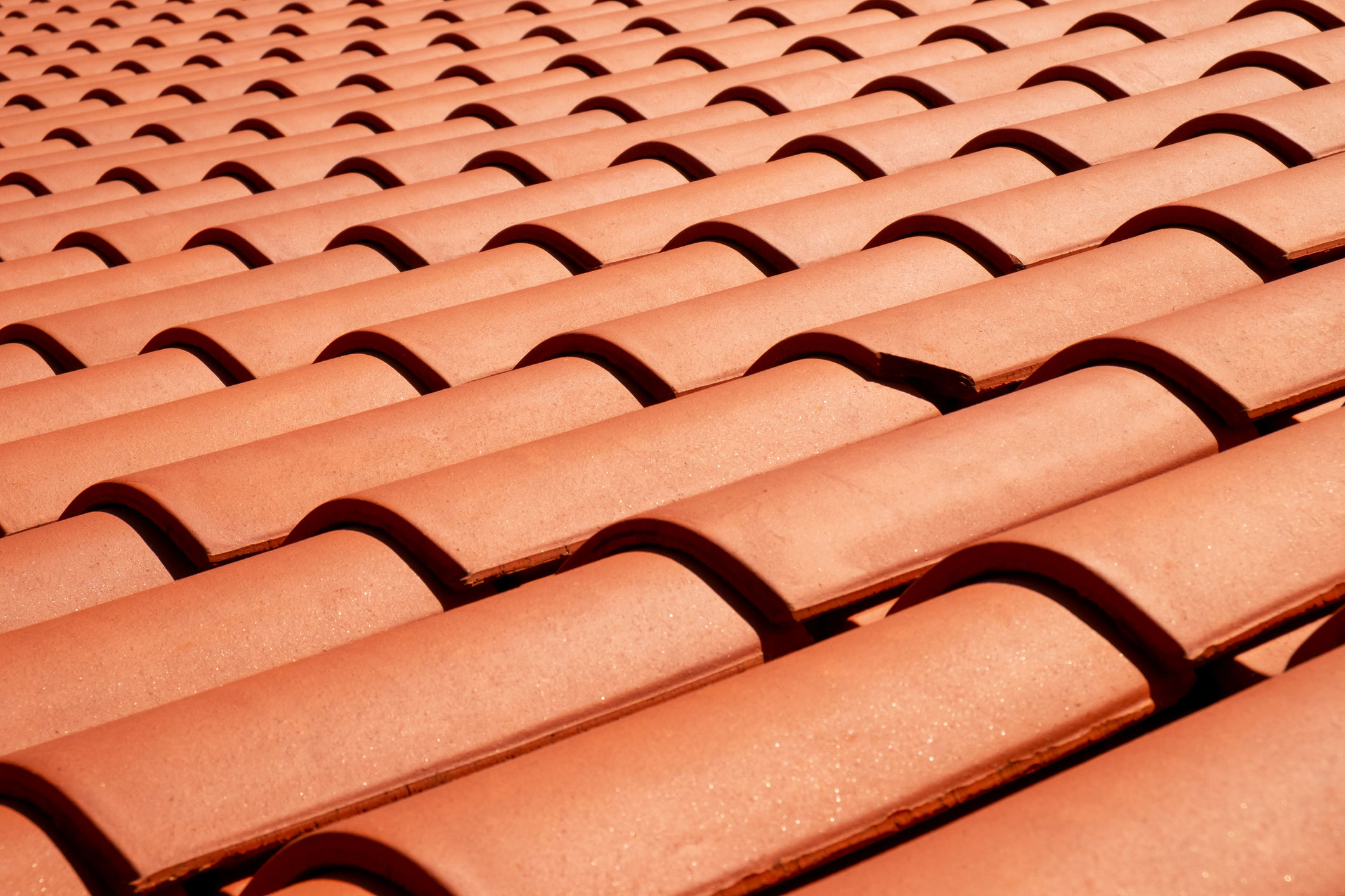 Close-up van nieuwe terracotta dakpannen, symbool voor een vernieuwd en goed onderhouden dak.