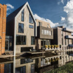 Moderne duurzame woningen langs het water, met diverse architectonische stijlen.