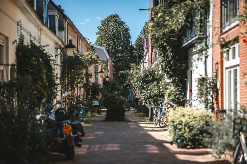 Knusse straat met groene gevels, fietsen en lantaarnpalen in een rustige wijk in Utrecht, mogelijk Wittevrouwen.