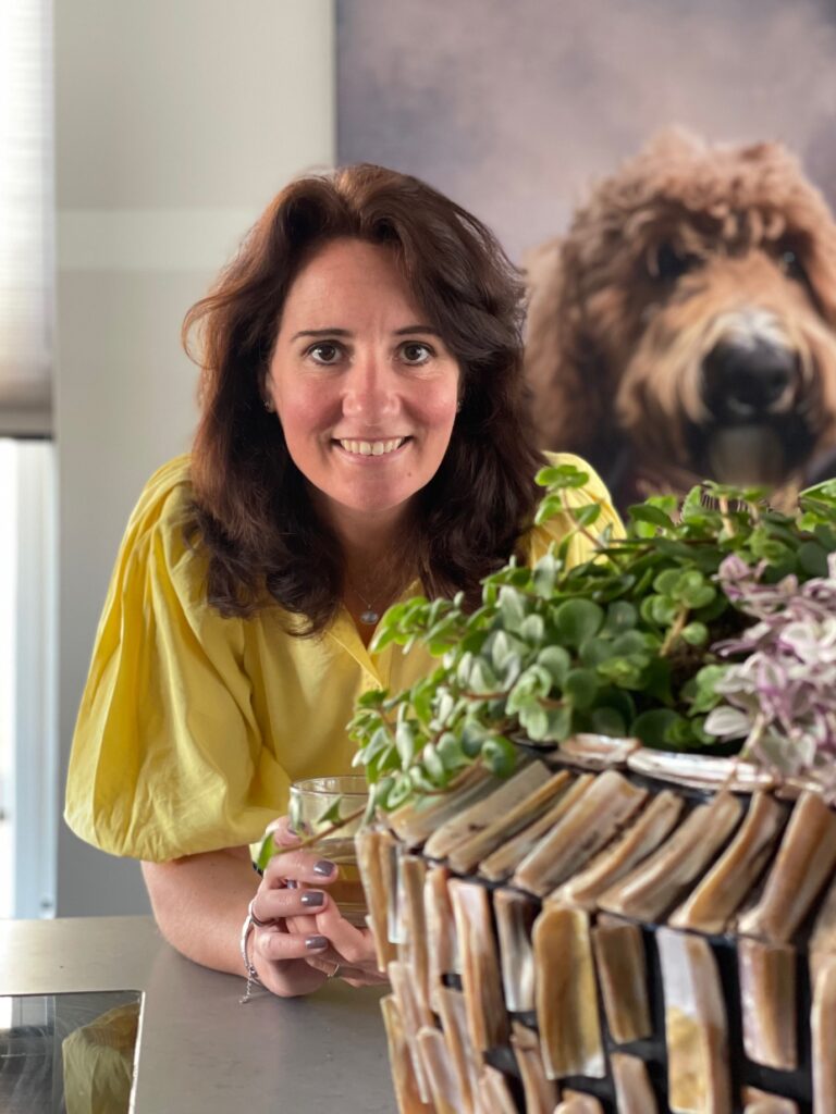 Interieurstylist Inge Jongste, blogger op Huislijn.nl, geniet van een kop thee aan de keukentafel, omringd door sfeervolle decoratie.