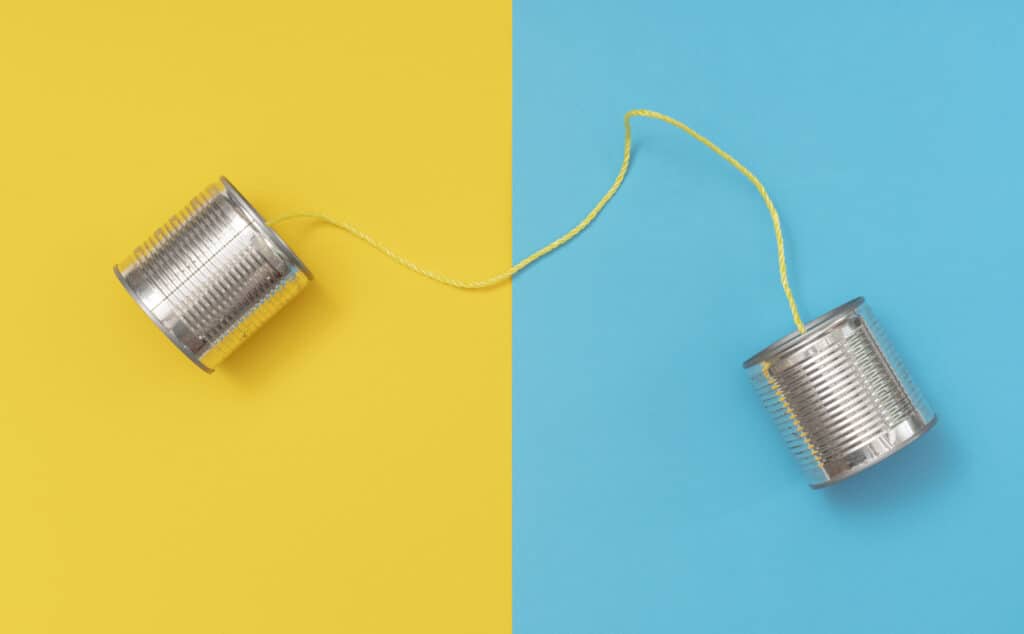 Twee blikken met een draad ertussen als metafoor voor ouderwetse communicatie tegenover moderne glasvezelverbinding
