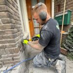Vakman brengt spouwmuurisolatie aan bij een woning voor betere energie-efficiëntie