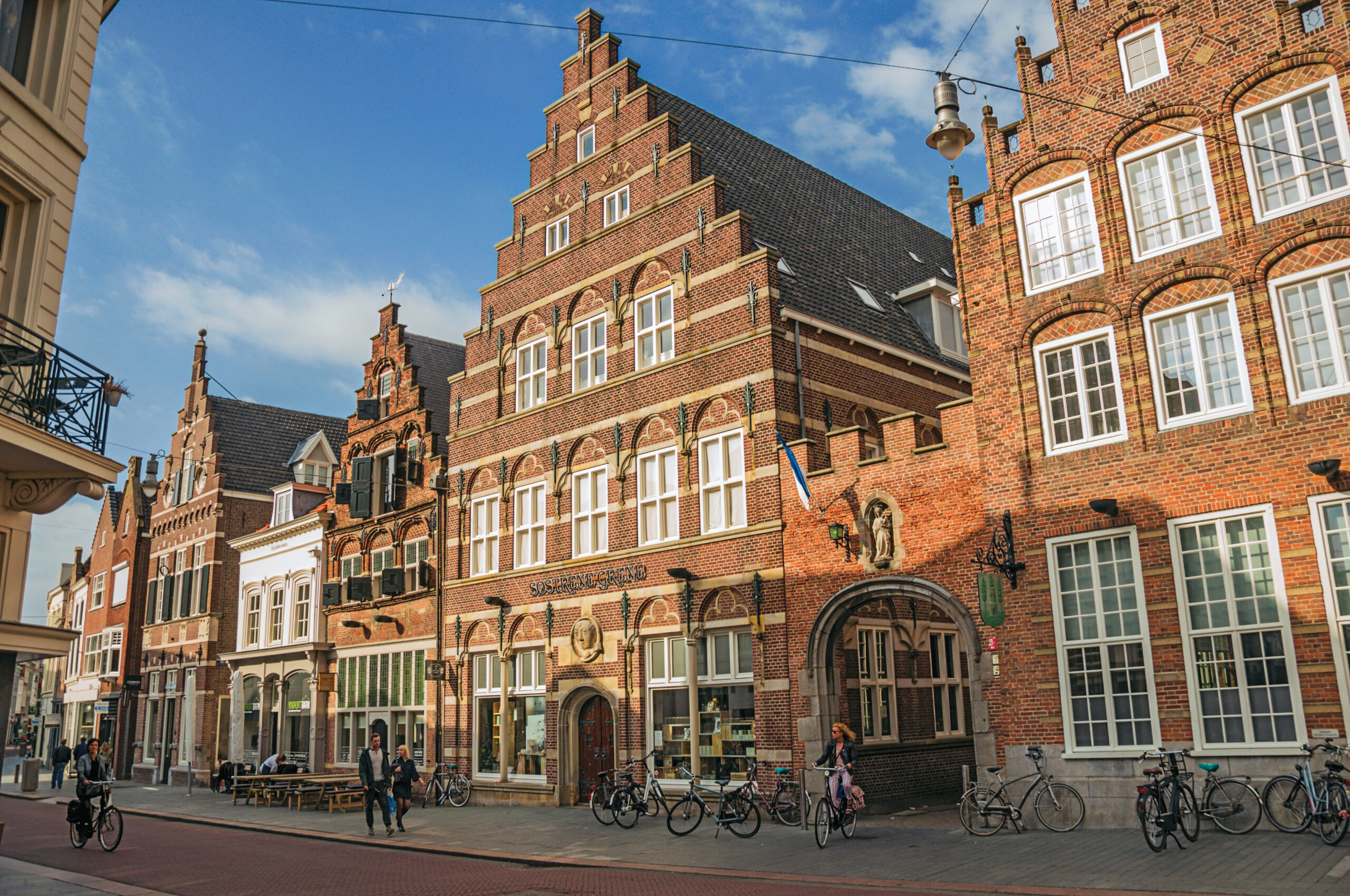 Historische gevels en fietsers in de binnenstad van Den Bosch op een zonnige dag