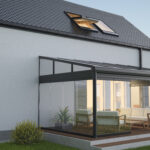 Terrasoverkapping met glazen zijwanden en zithoek aan een moderne woning, ideaal voor comfort in elk seizoen
