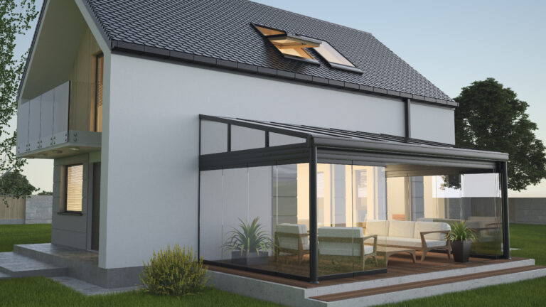 Terrasoverkapping met glazen zijwanden en zithoek aan een moderne woning, ideaal voor comfort in elk seizoen