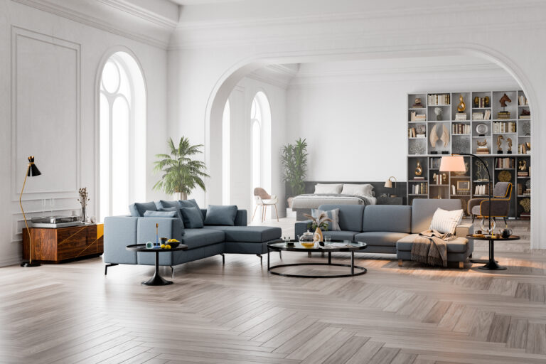 Luxe woonkamer met visgraat houten vloer, blauwe bank en hoge ram