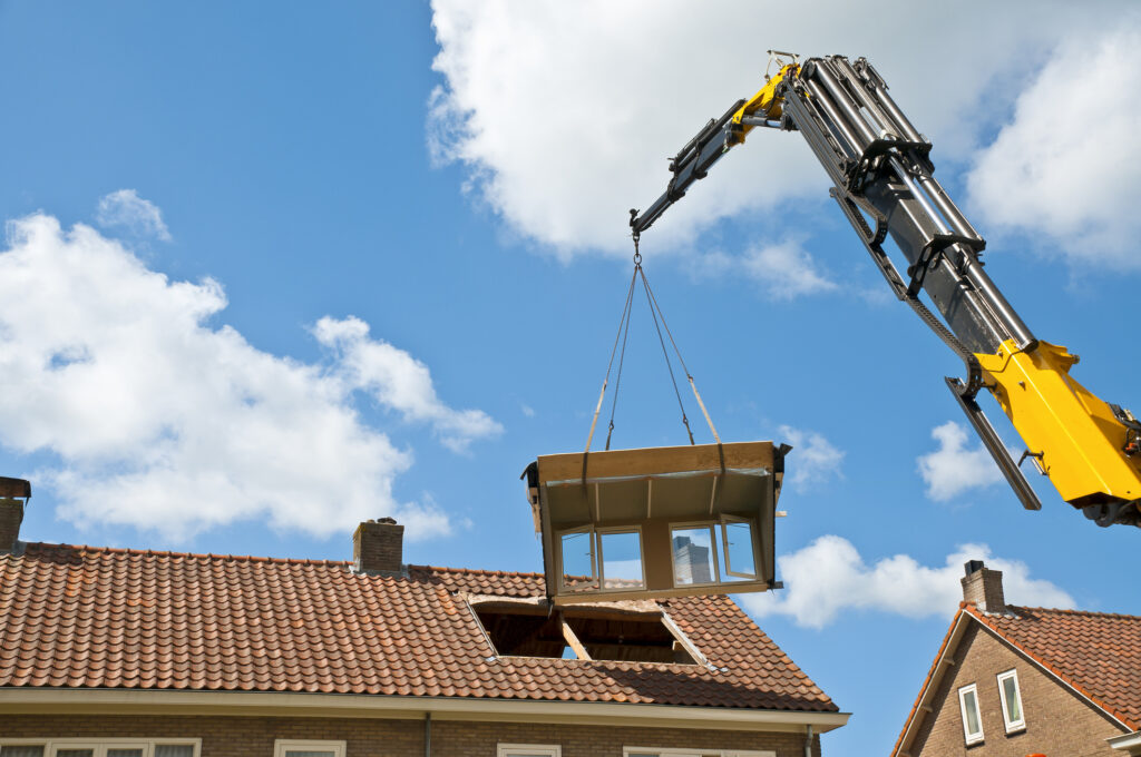 Plaatsing van een prefab dakkapel met hijskraan op een rijtjeshuis