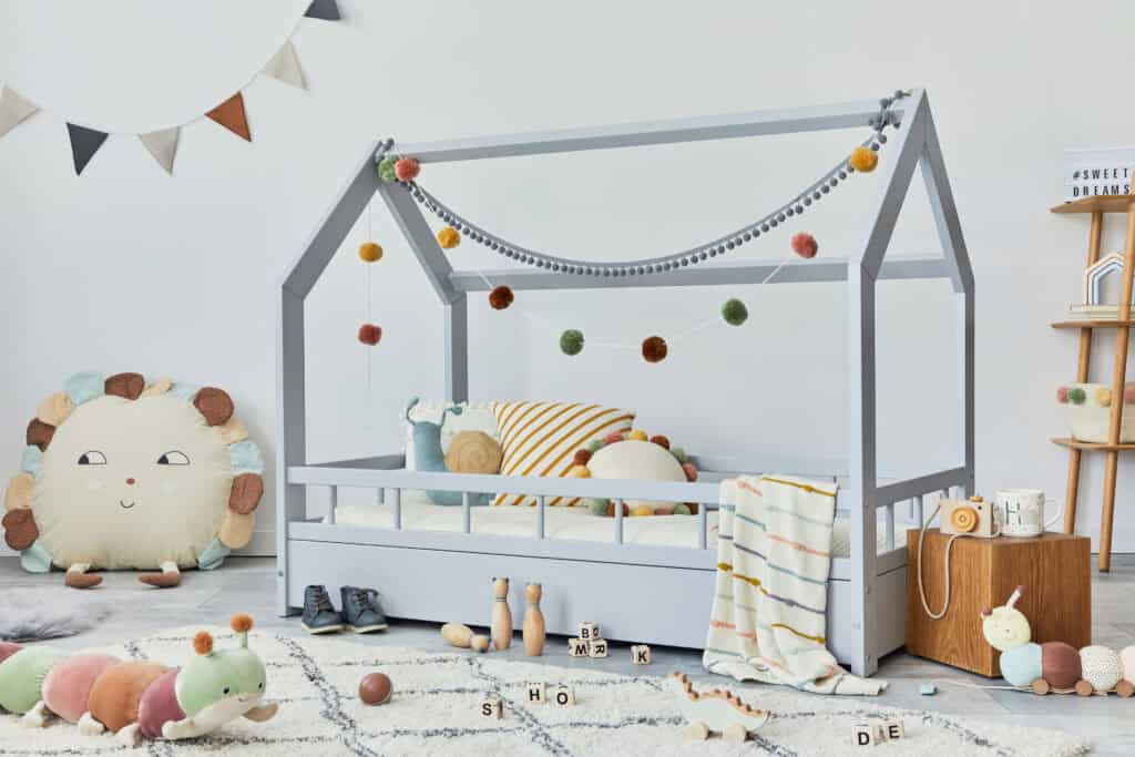 Kinderkamer met houten huisbed, zacht speelkleed en houten speelgoed in rustige kleuren