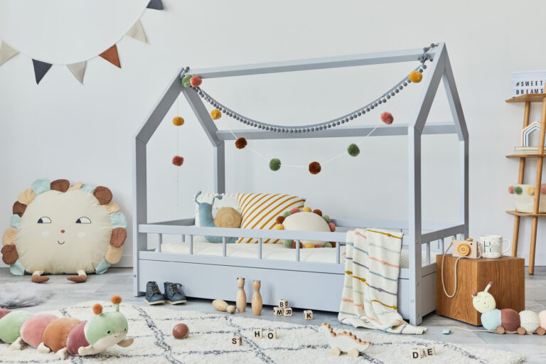 Kinderkamer met houten huisbed, zacht speelkleed en houten speelgoed in rustige kleuren