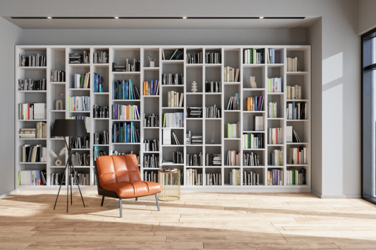 Grote open boekenkast met gesorteerde boeken en leren fauteuil in sfeervolle woonkamer