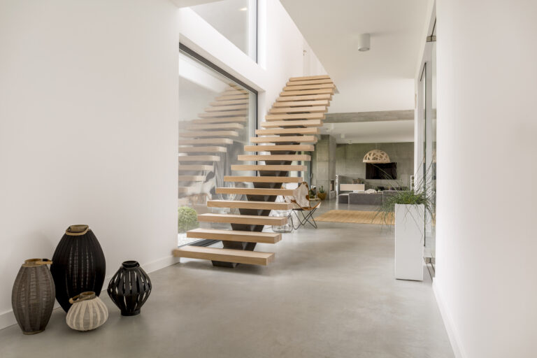Minimalistische houten trap in een lichte moderne woning met open woonkamer