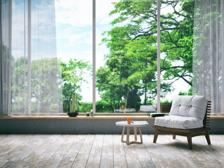 Licht interieur met houtlook PVC vloer en uitzicht op groene bomen
