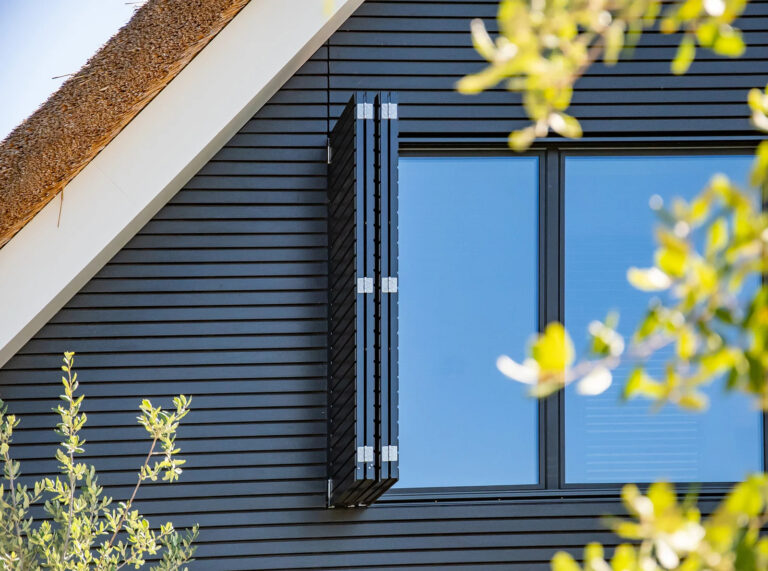 Moderne woning met opklapbare houten zonwering en zwarte gevelbekleding