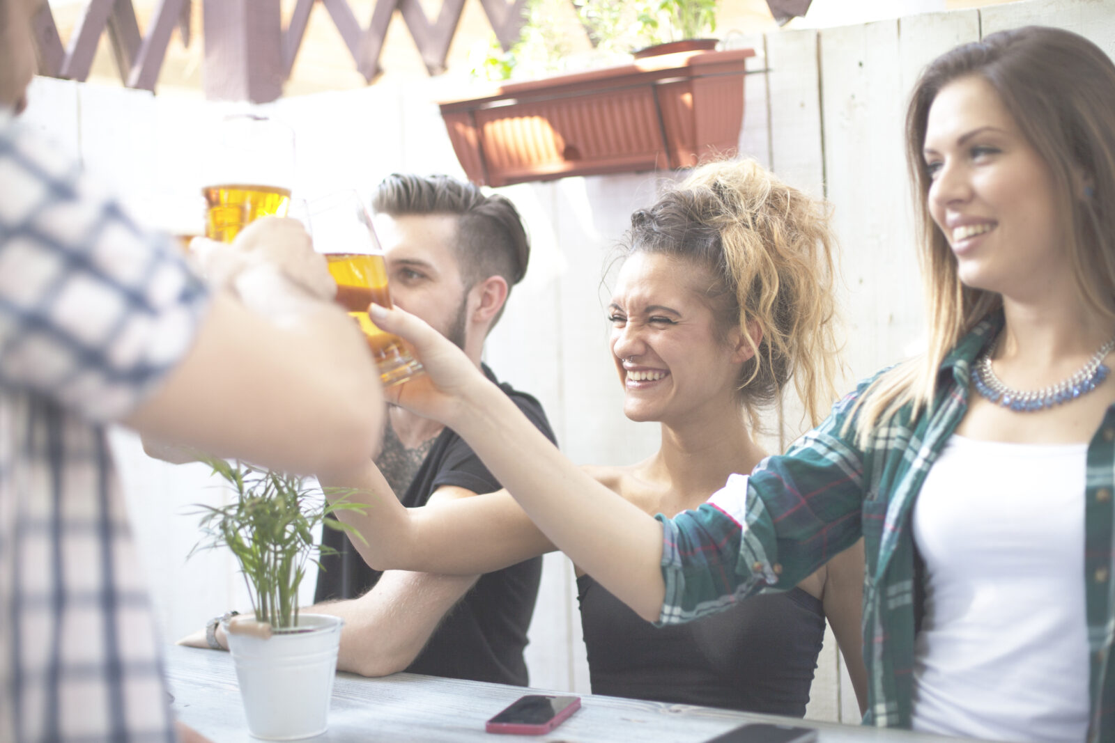 Groep vrienden proost met bier tijdens een dorpsfeest in zonnige tuinomgeving