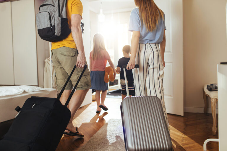 Gezin met koffers verlaat woning om op vakantie te gaan, huis blijft onbeheerd achter.