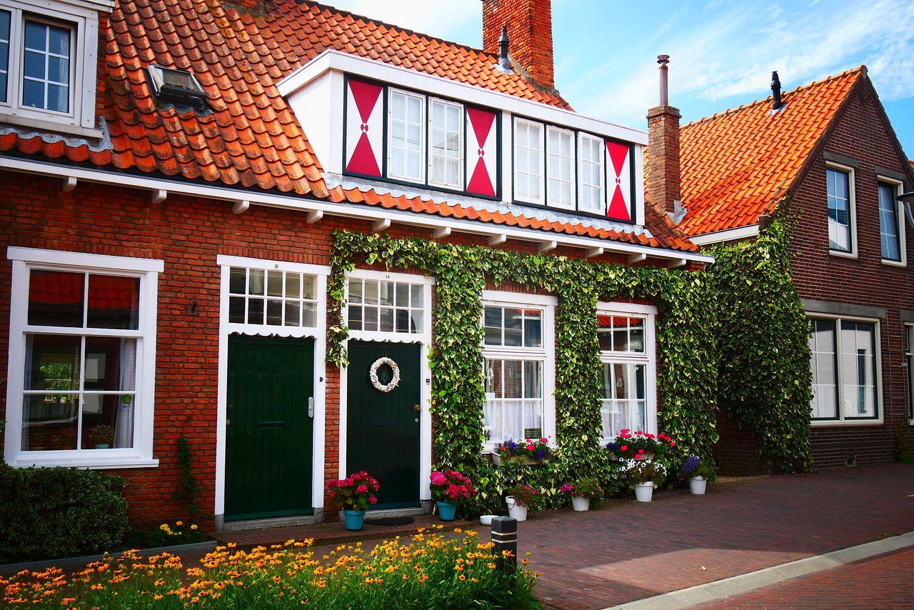 Historische Nederlandse woning met rode dakpannen, witte kozijnen en klimplanten langs de gevel