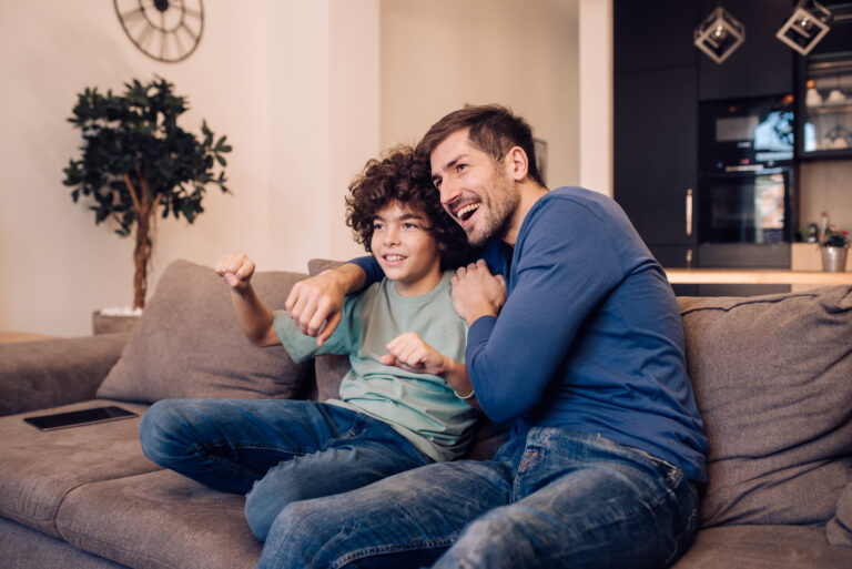Gezellig stel dat ontspannen televisie kijkt op de bank in een moderne woonkamer