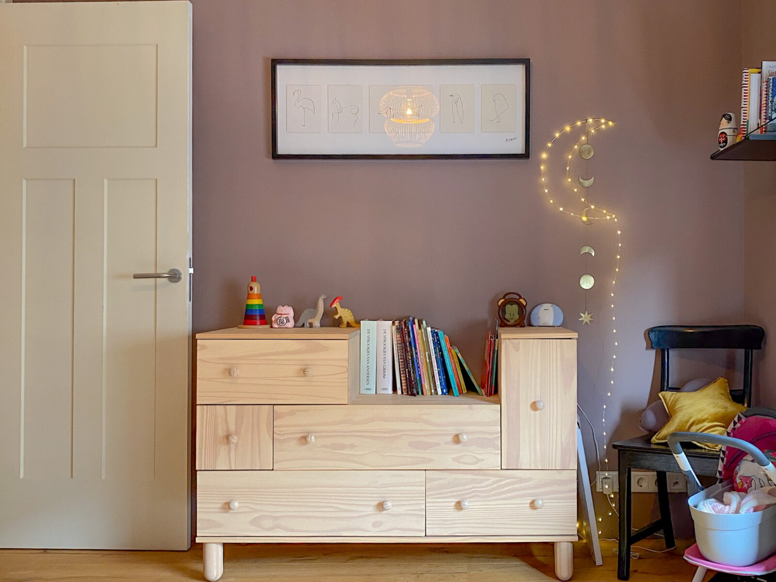 Gezellige kinderkamerhoek met houten kast, boeken en zachte verlichting – ontwerp van Bente Metselaar
