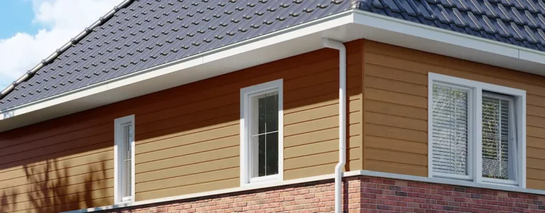 Woning met kunststof gevelbekleding in houtlook onder een donker pannendak