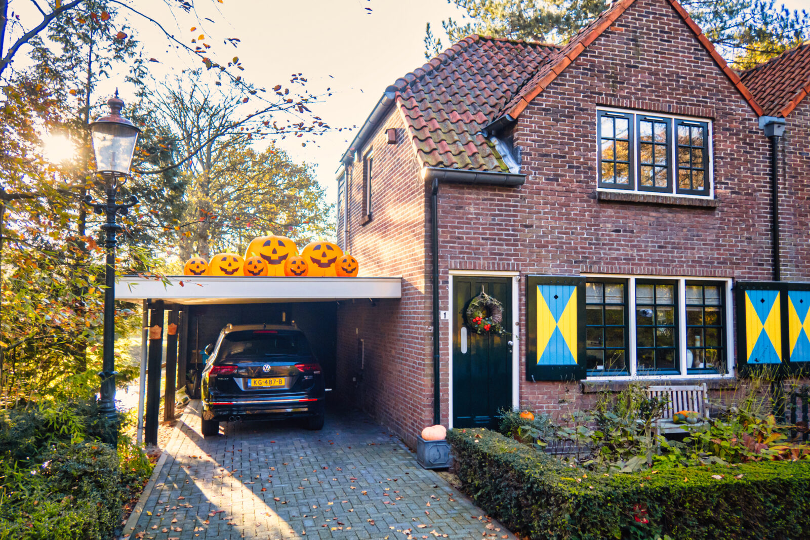 Traditioneel Nederlands huis met houten carport en auto op de oprit