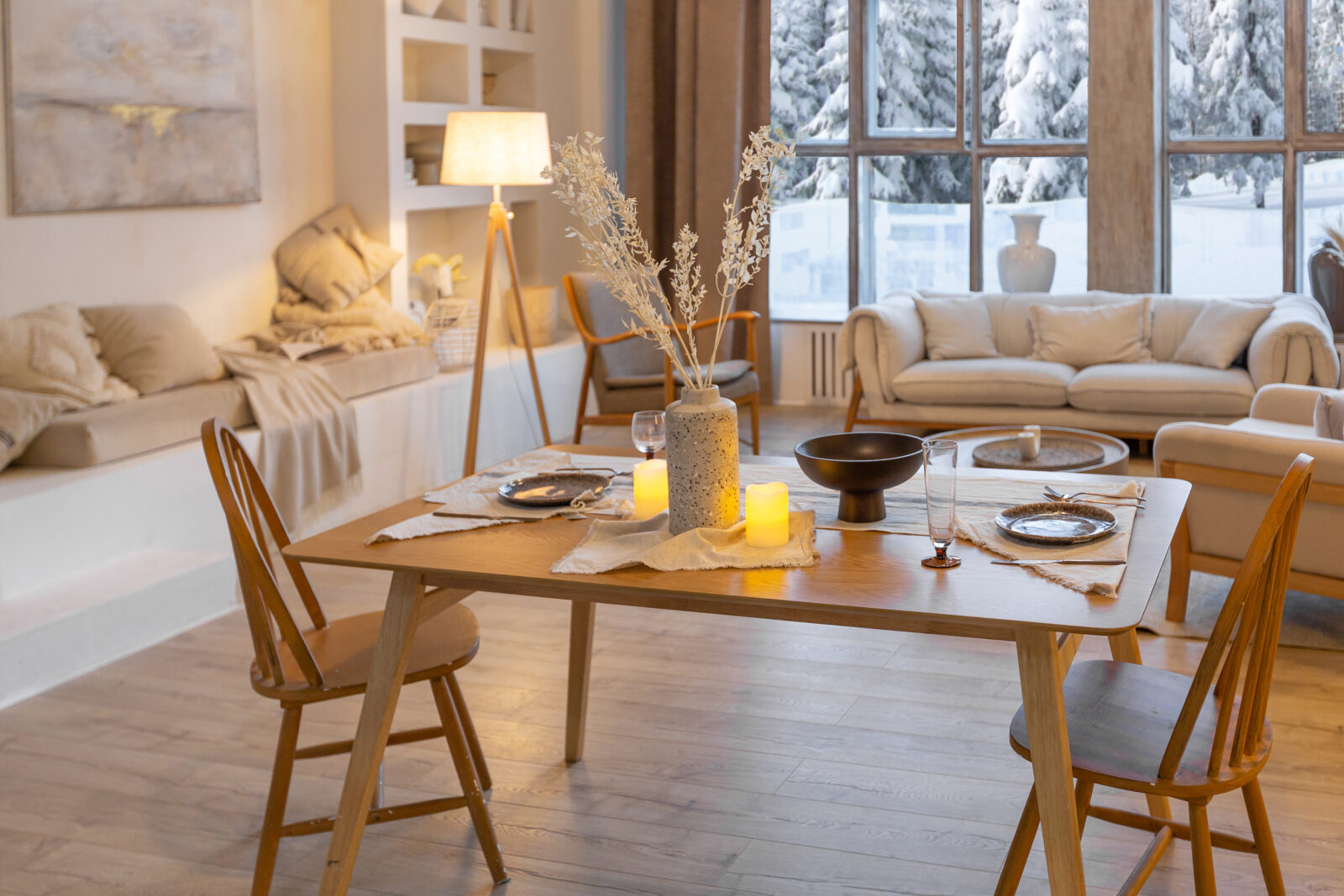 Minimalistische houten eettafel met HAY-stijl kandelaars en zacht kaarslicht in een warme, Scandinavische woonkamer