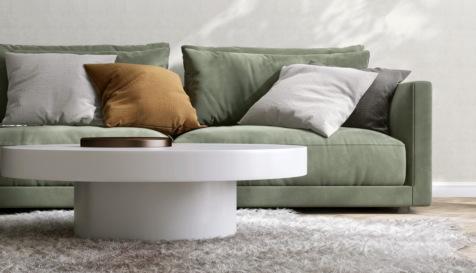 Ronde witte salontafel met groene bank en zachte kussens in een compacte, lichte woonkamer.