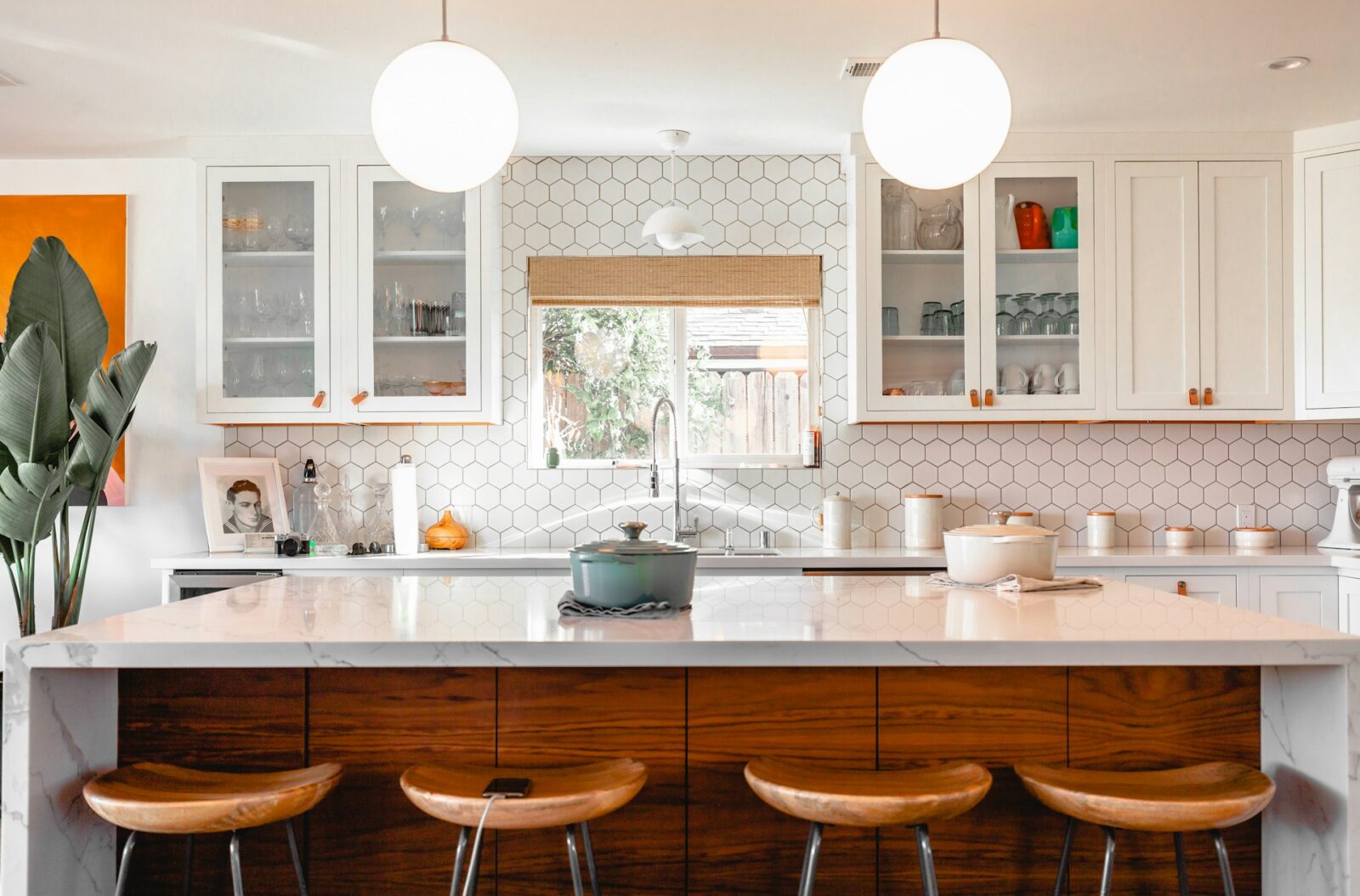 Keuken met bar en drie krukken, lichte tegels en houtaccenten in een vakantiewoning.