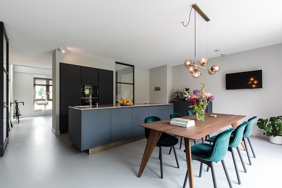Moderne keuken en eethoek met een lichte gietvloer die de ruimte ruimtelijk en strak laat ogen.