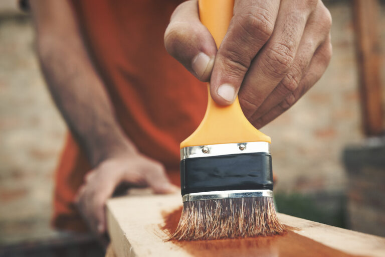 Detail van houten buitenwerk dat wordt afgewerkt met hoogglans verf