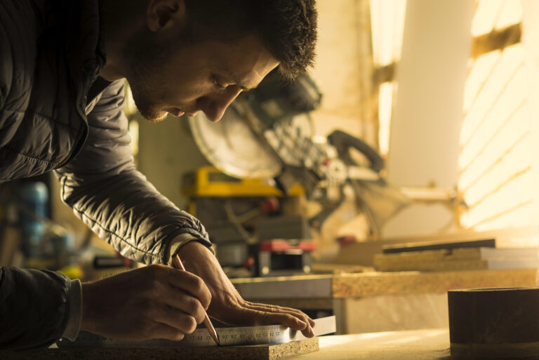 Iemand meet en markeert hout als voorbereiding op een klus in huis