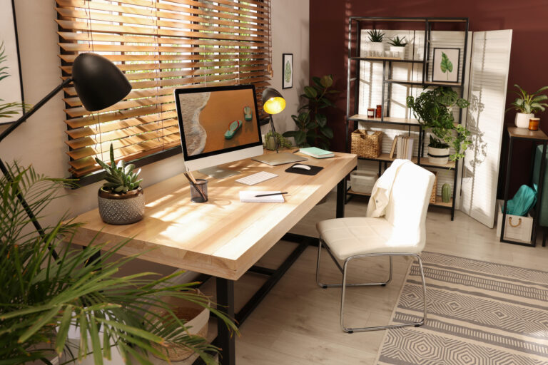 Rustige thuiswerkplek met houten bureau, planten en warm natuurlijk licht.