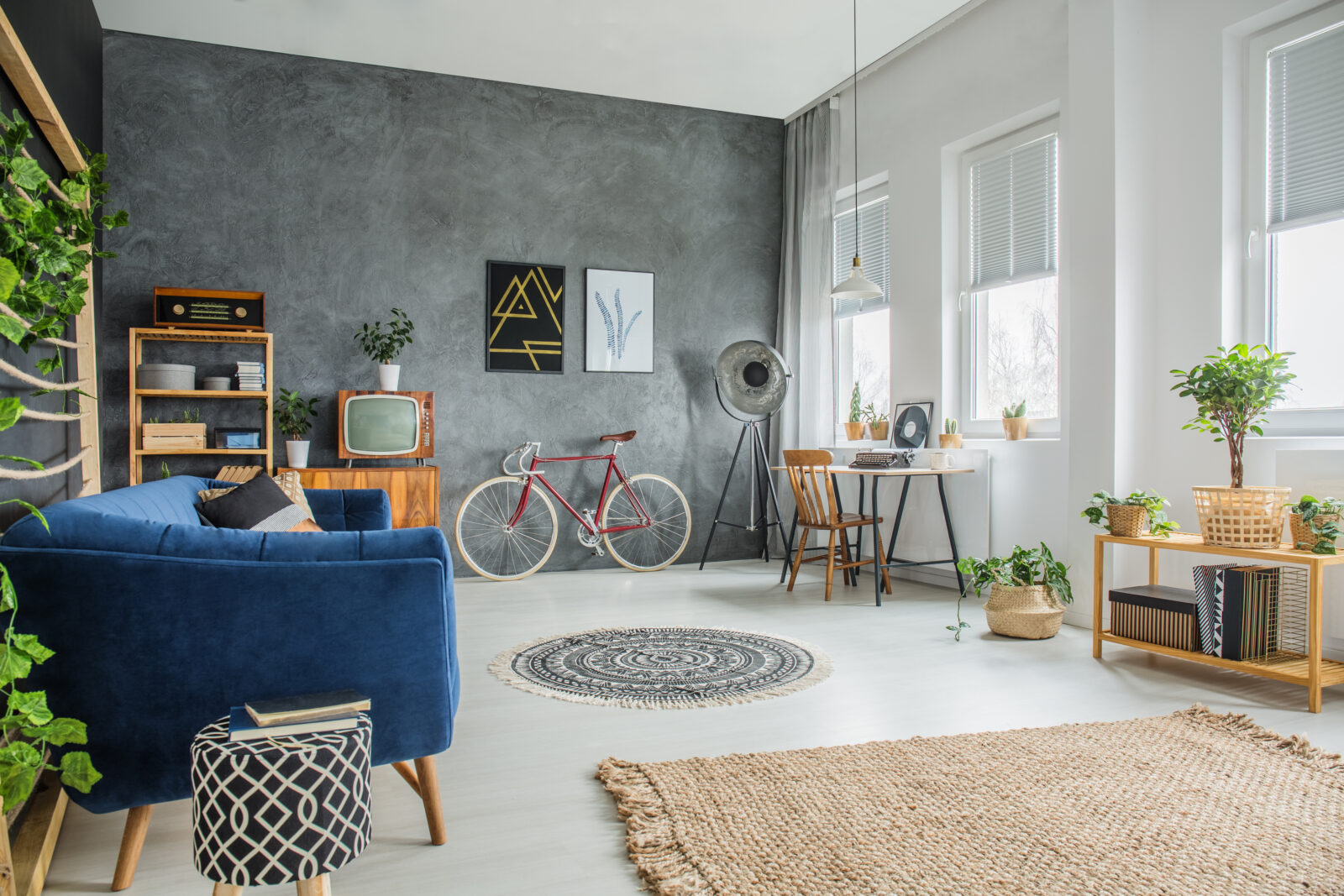 Betaalbaar ingerichte woonkamer met tweedehands meubels, planten en daglicht