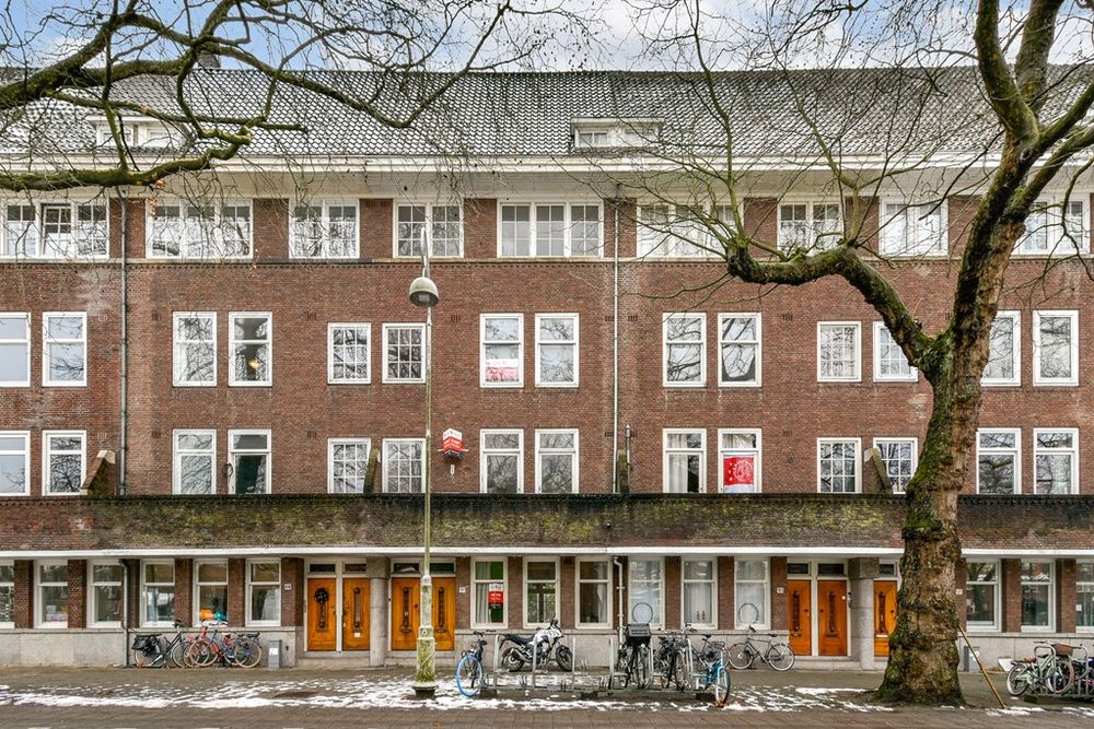 Portiekwoningen aan de Apollolaan met ritmische gevels en volwassen bomen