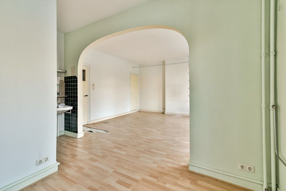 Binnenruimte met boogvormige doorgang en eenvoudige afwerking in woning aan de Apollolaan